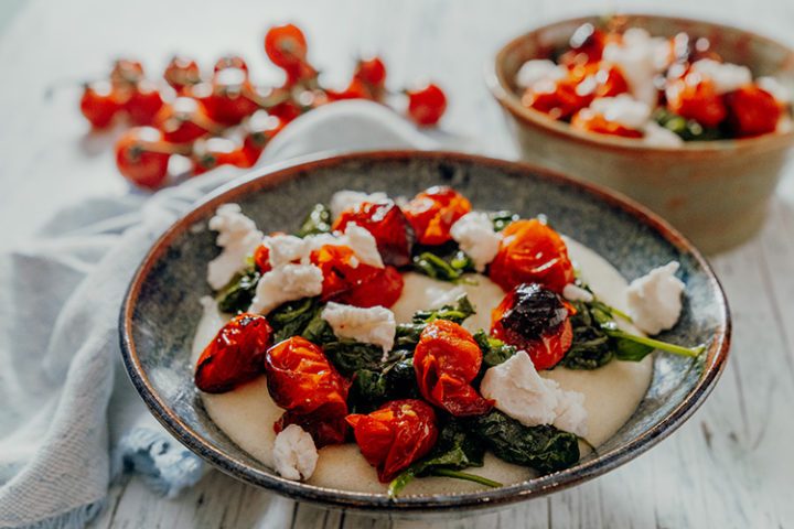 Cremige weiße Ziegenkäse-Polenta mit Tomaten und Spinat