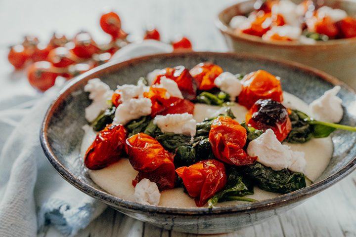 Cremige weiße Ziegenkäse-Polenta mit Tomaten und Spinat