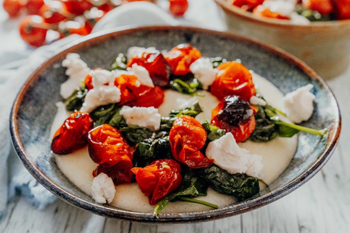 Cremige weiße Ziegenkäse-Polenta mit Tomaten und Spinat